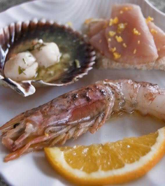 Gamberone crudo marinato all'arancia e sale nero di Ciprocrostino di pane kamut e spada affumicato capasanta alla veneziana.